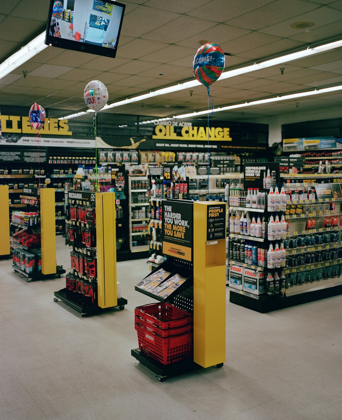 Een auto-onderdelenwinkel met gangpaden vol automaterialen in schappen.