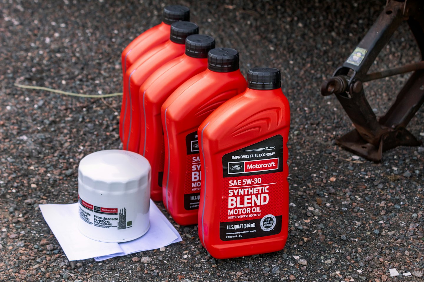 Motorcraft olieflesjes en filter op asfalt.