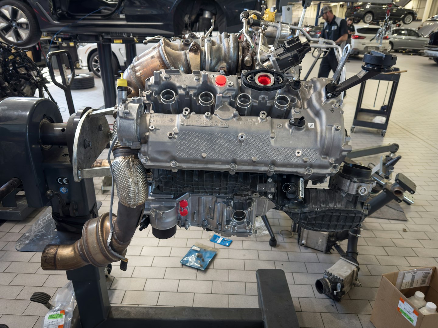Gedemonteerde motor op een standaard in een werkplaats.