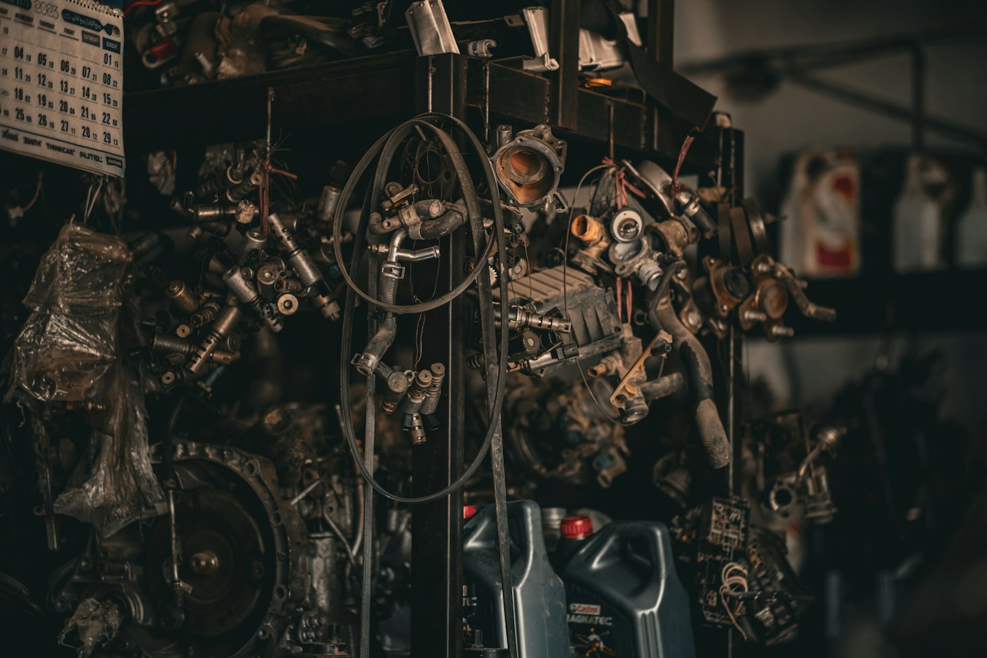 Rommelige plank met gebruikte auto-onderdelen en oliekannen.